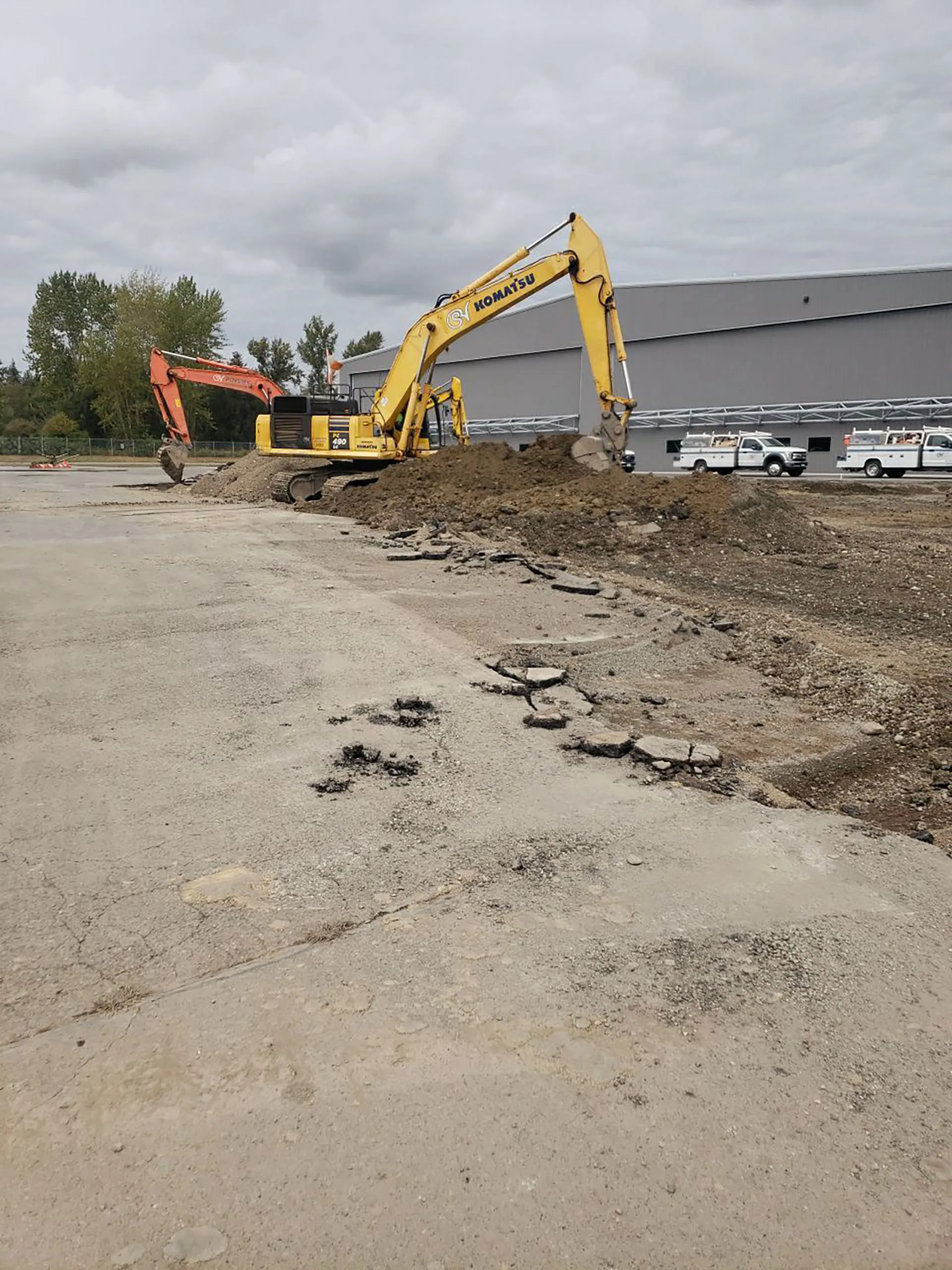 A yellow excavator is parked in front of a building.