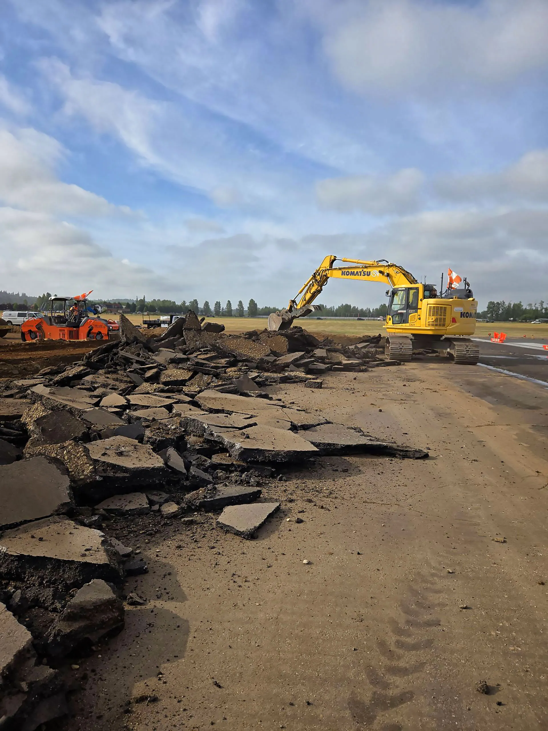 A yellow construction machine is working on a road.