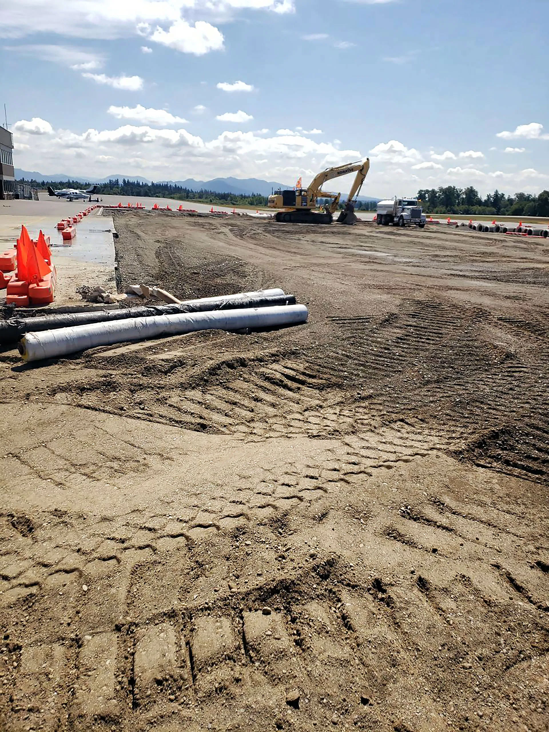 A large construction site with a yellow pipe and a large piece of machinery.