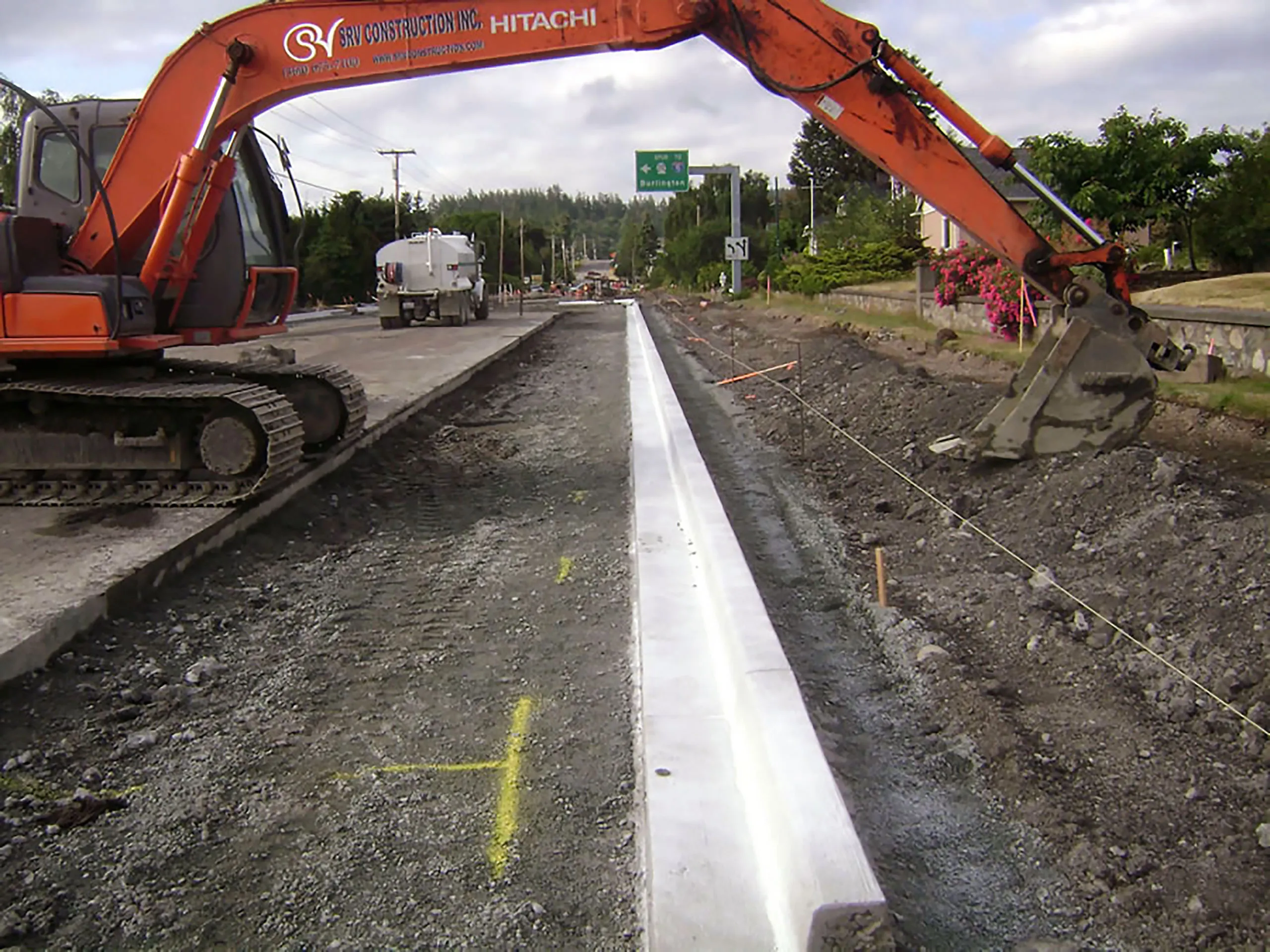 A construction site with a yellow line and a red bulldozer.