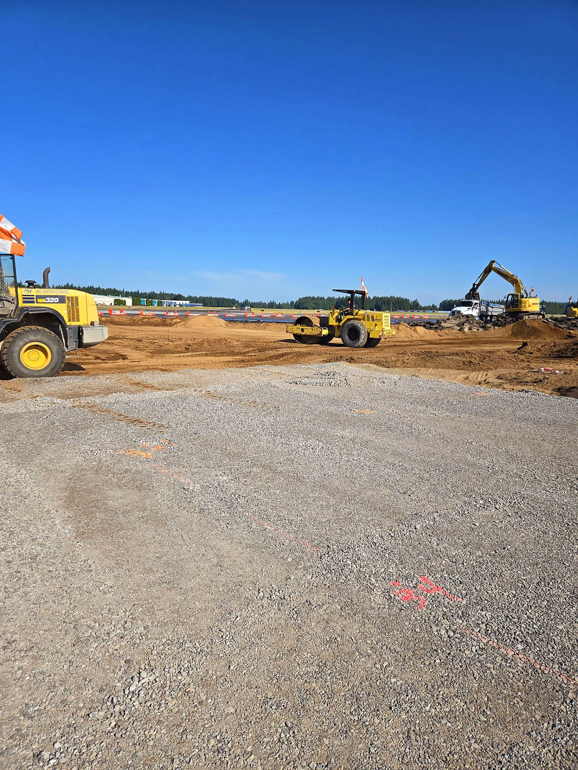 A yellow bulldozer is parked on a dirt road.