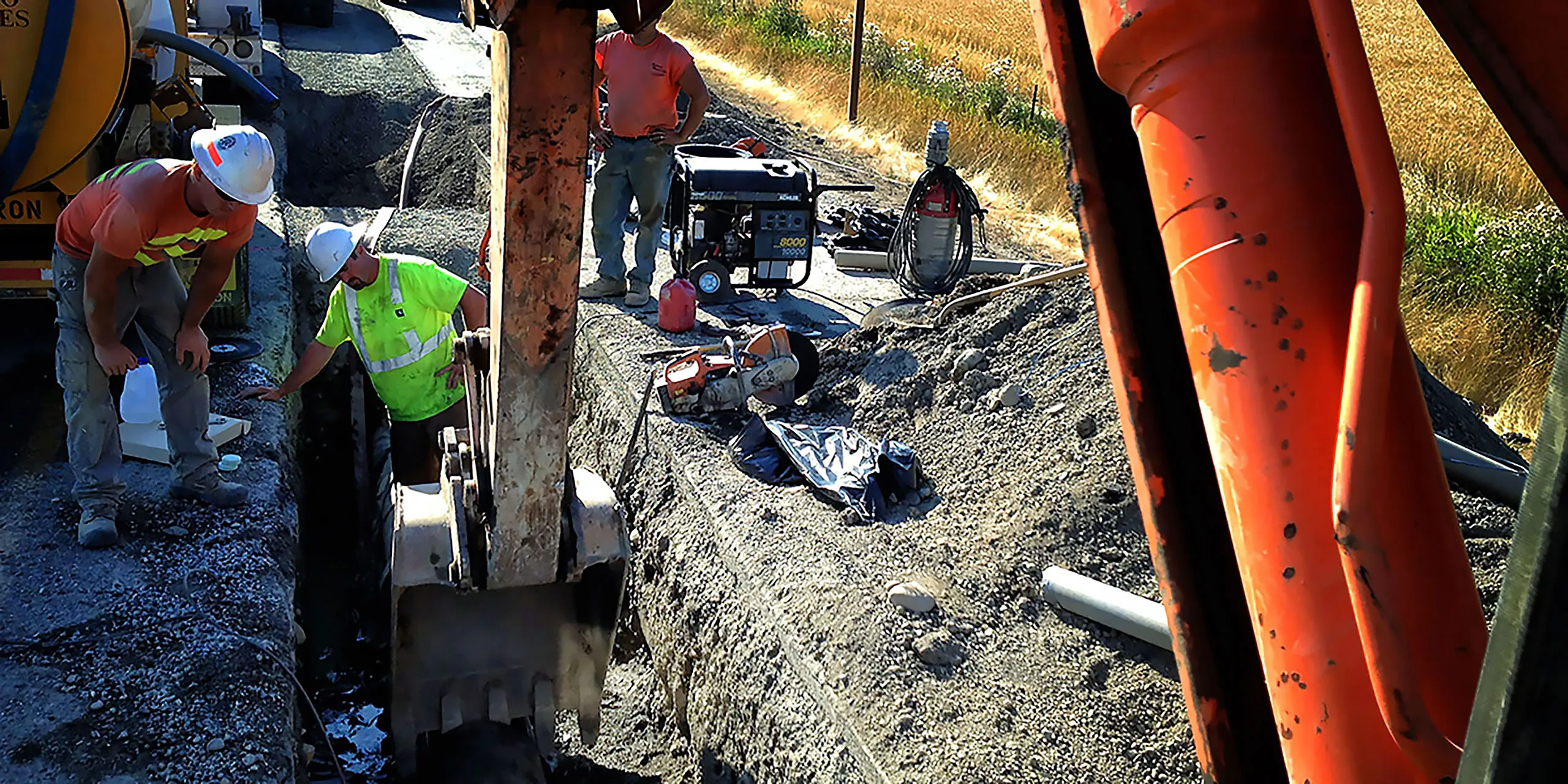 A man working on a machine in a dirt field.
