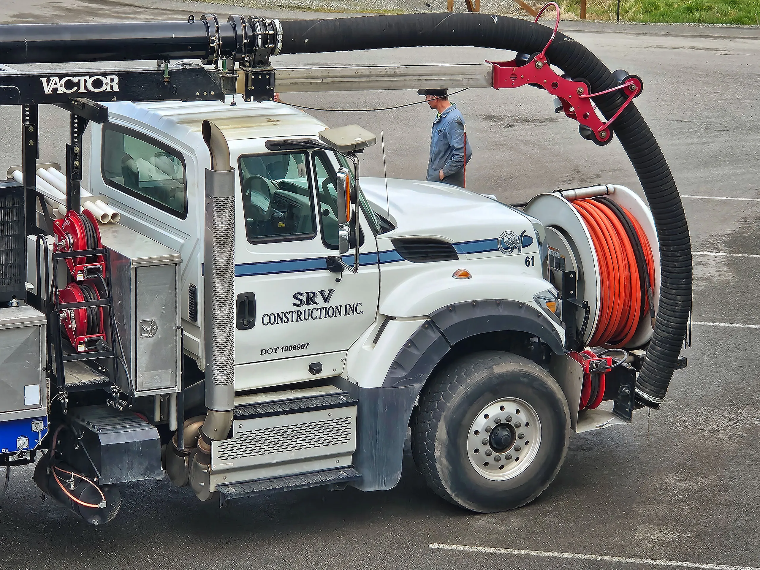 A white truck with a hose on the back.