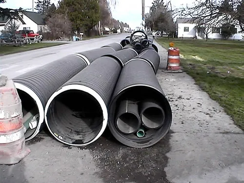 A bunch of pipes laying on the street.