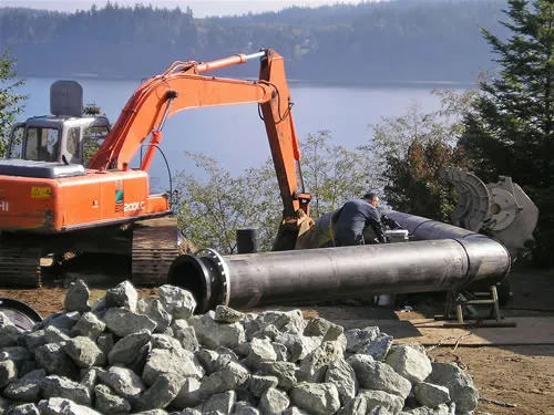 A man is working on a large pipe.