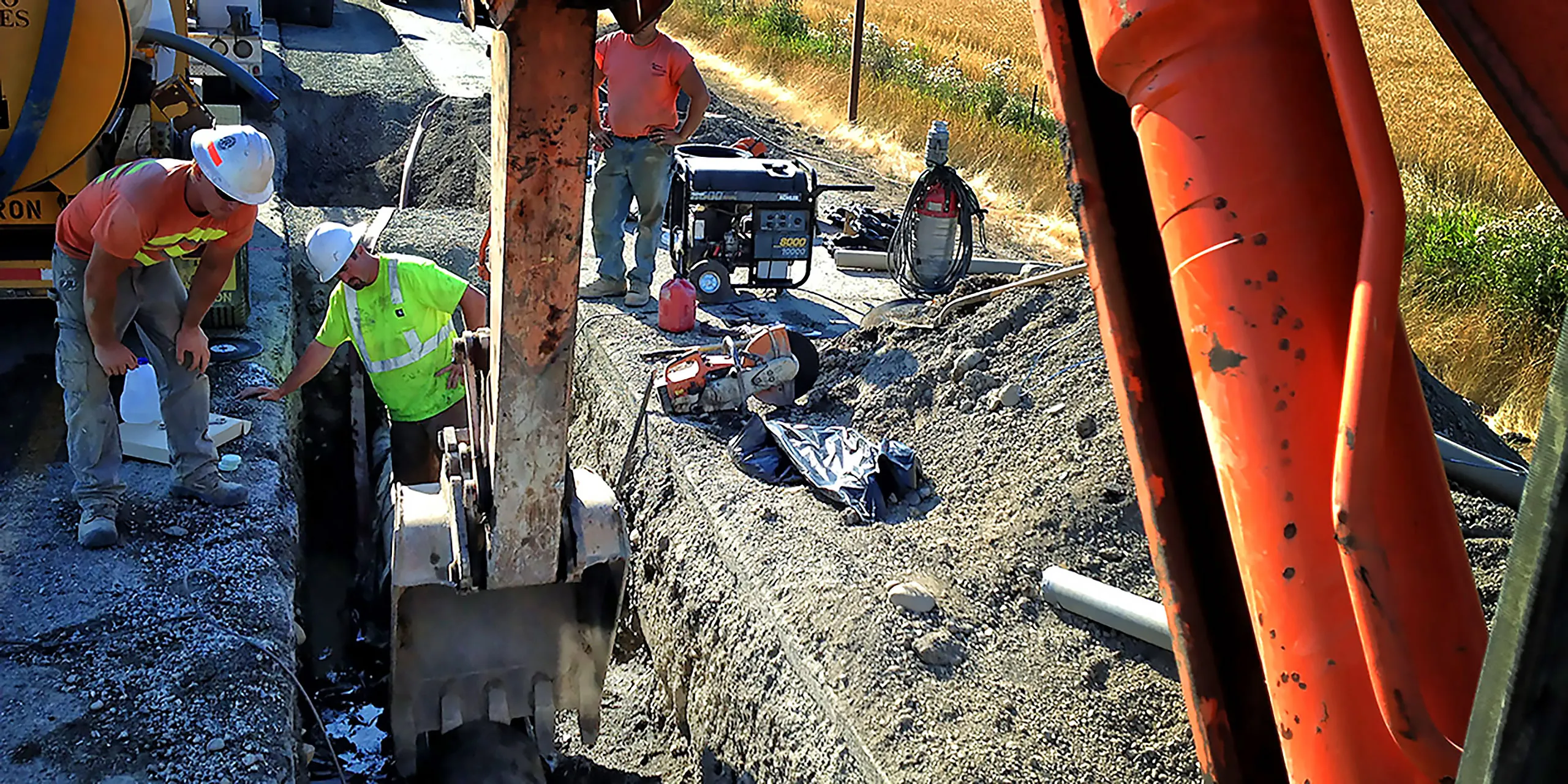 A man working on a machine in a dirt field.