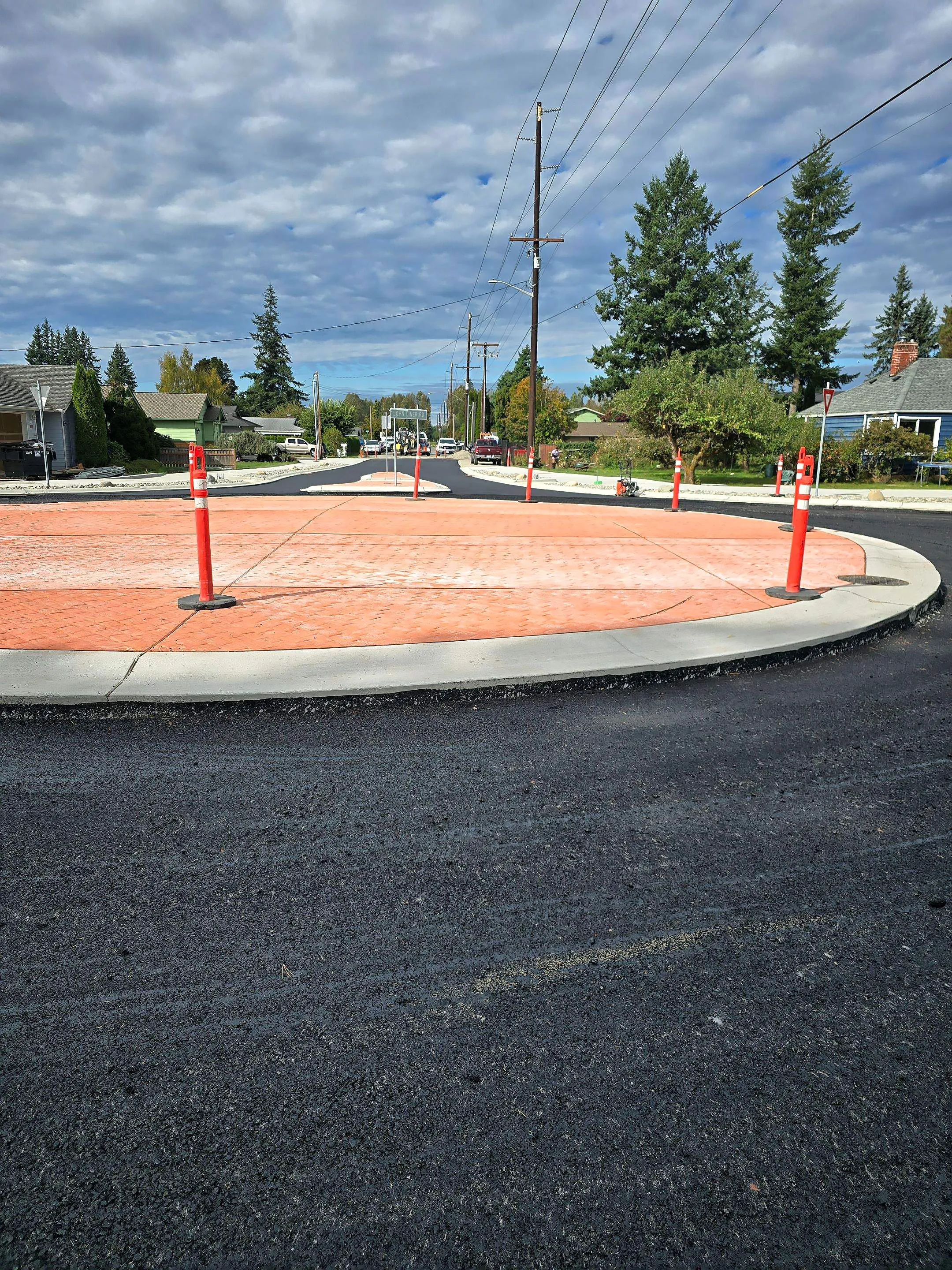A street with a red brick circle in the middle.