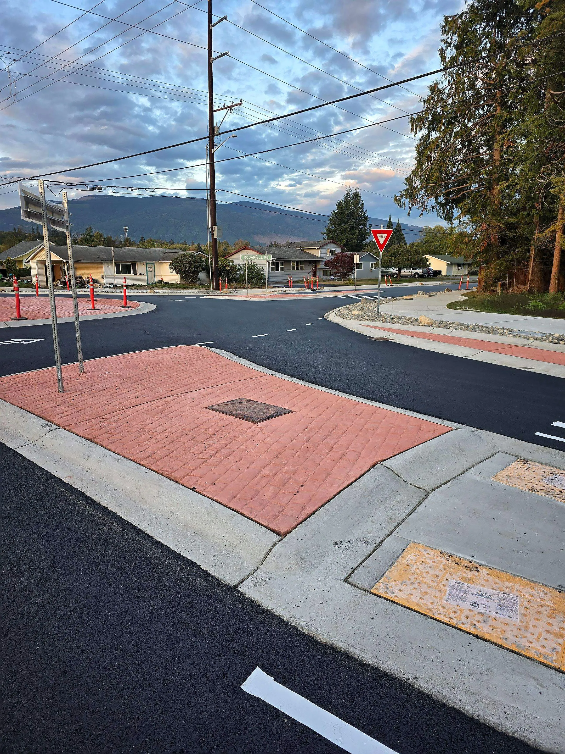 A street intersection with a red brick circle in the middle.
