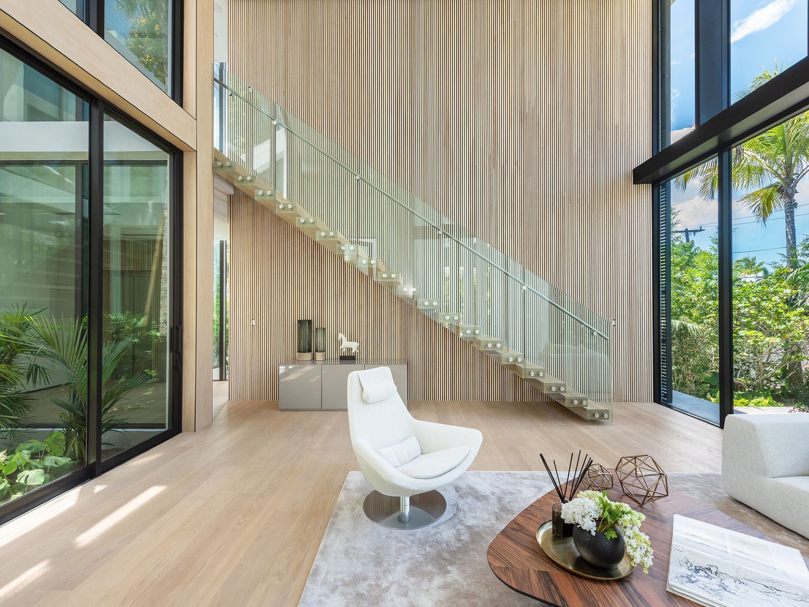 Double-height all-glass courtyard with glass-railed stair