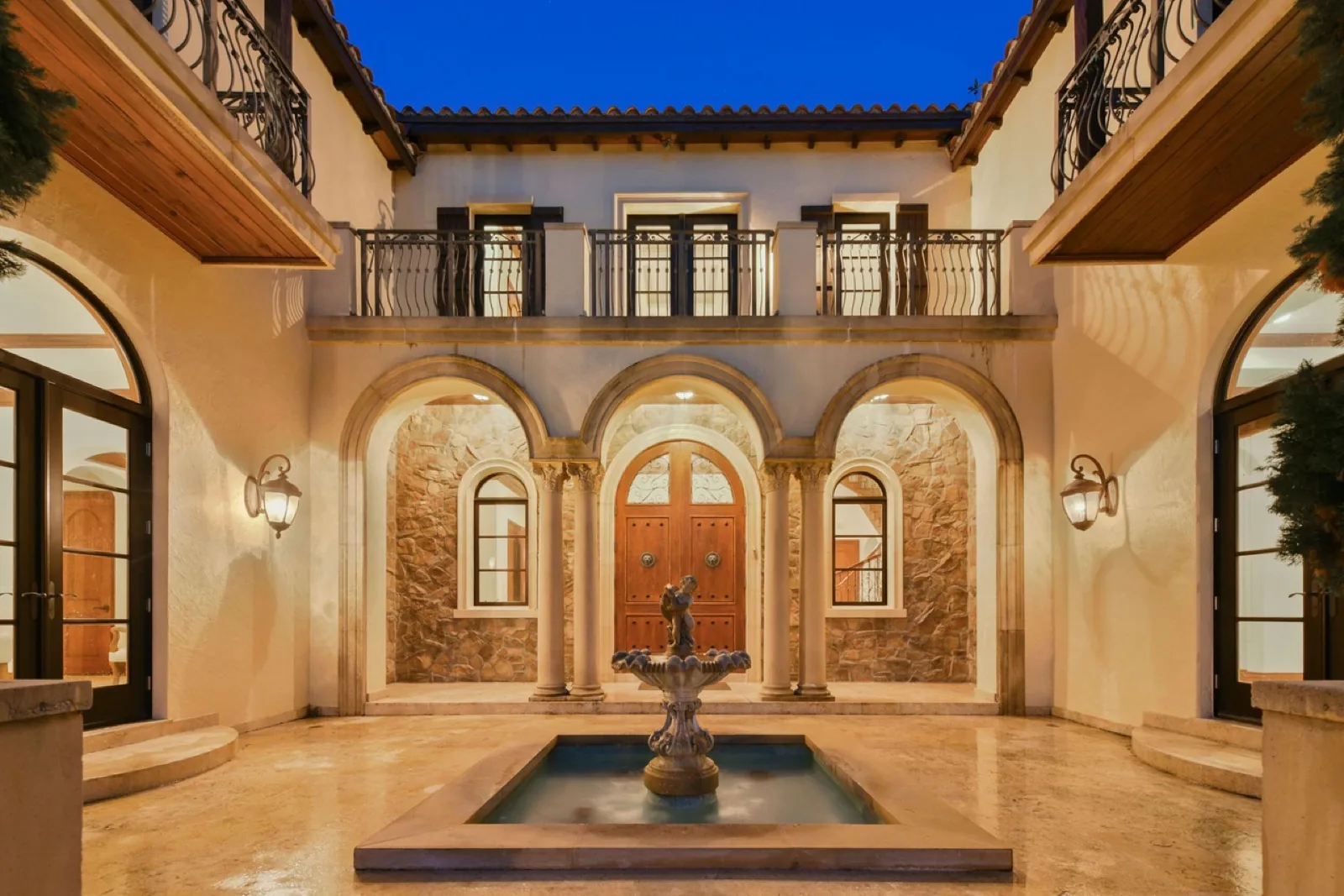 Grand wood entry doors of a contemporary home at dusk