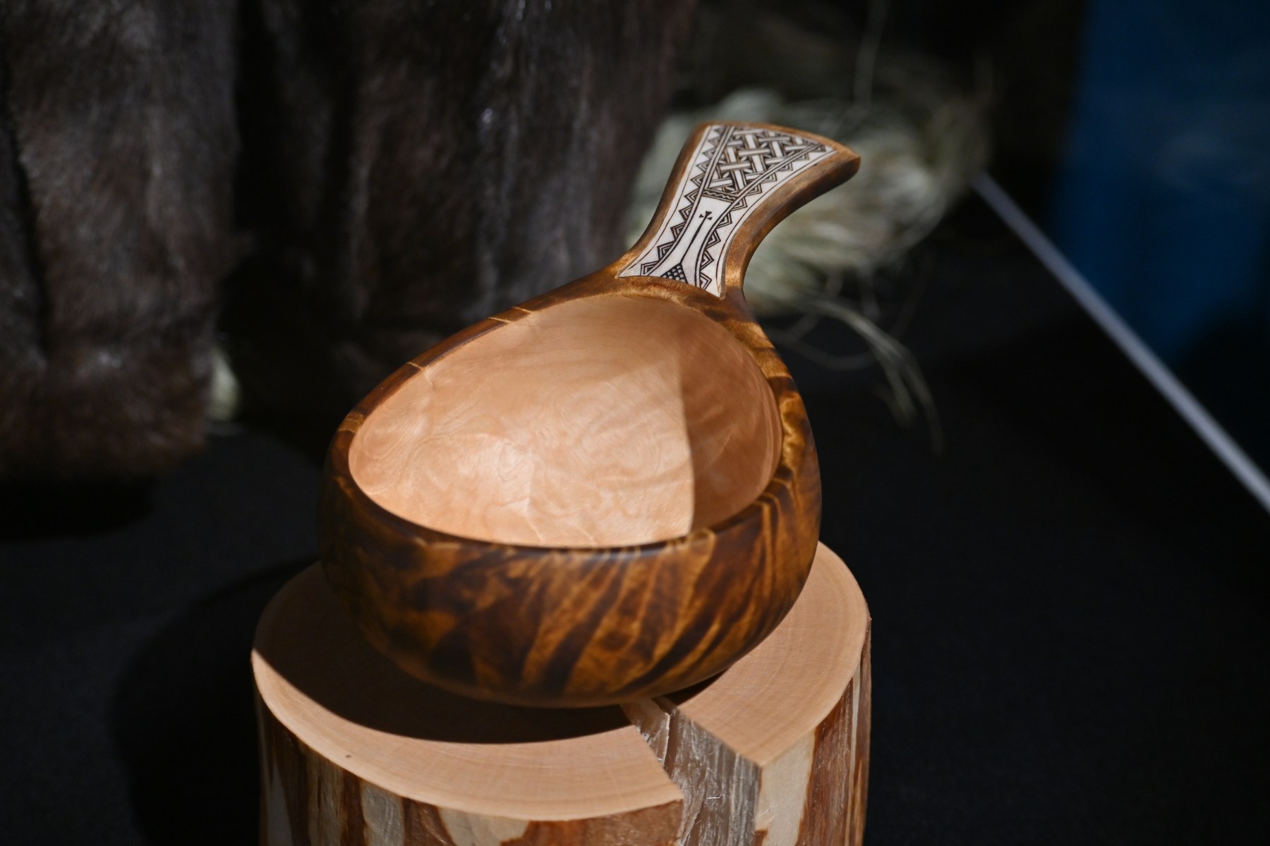 A birch guksi drinking cup with a carved reindeer antler handle