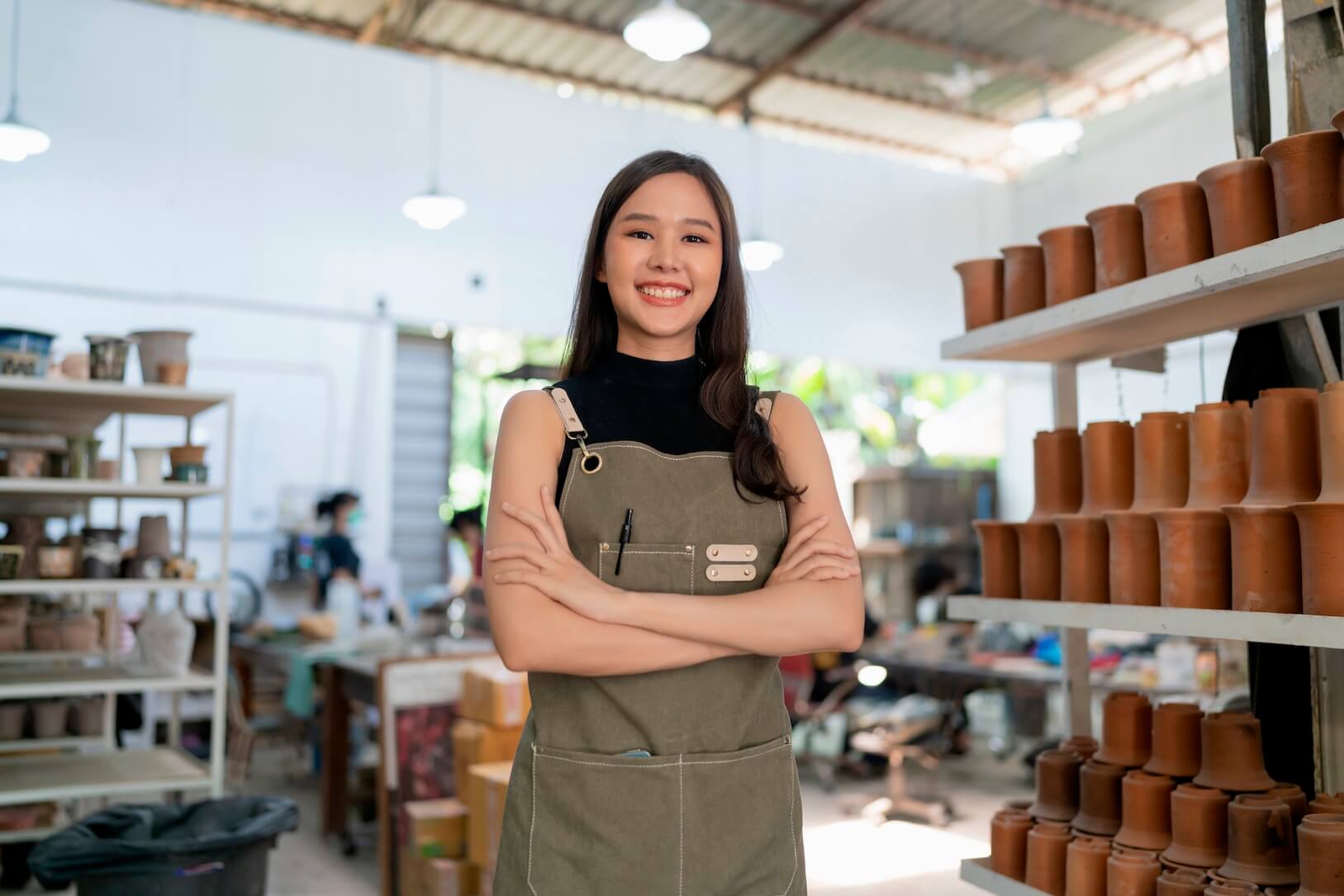 Smiling woman wearing a work apron in a kitchen, illustrating satisfaction expressed in a testimonial.