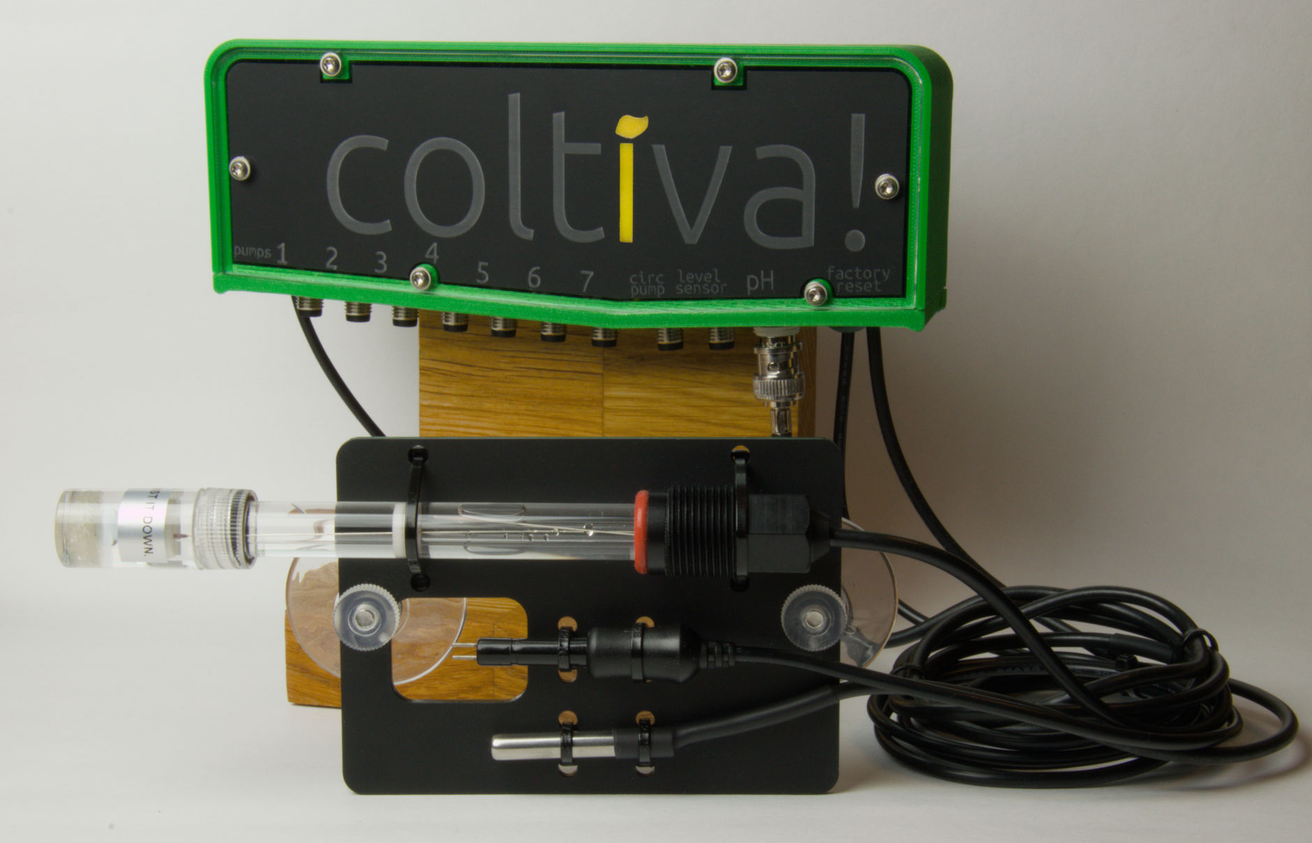 A Coltiva device mounted on a stand, with three sensors mounted on a holder displayed in front of the Coltiva device. The displayed sensors are for pH, conductivity (EC) and temperature, respectively.