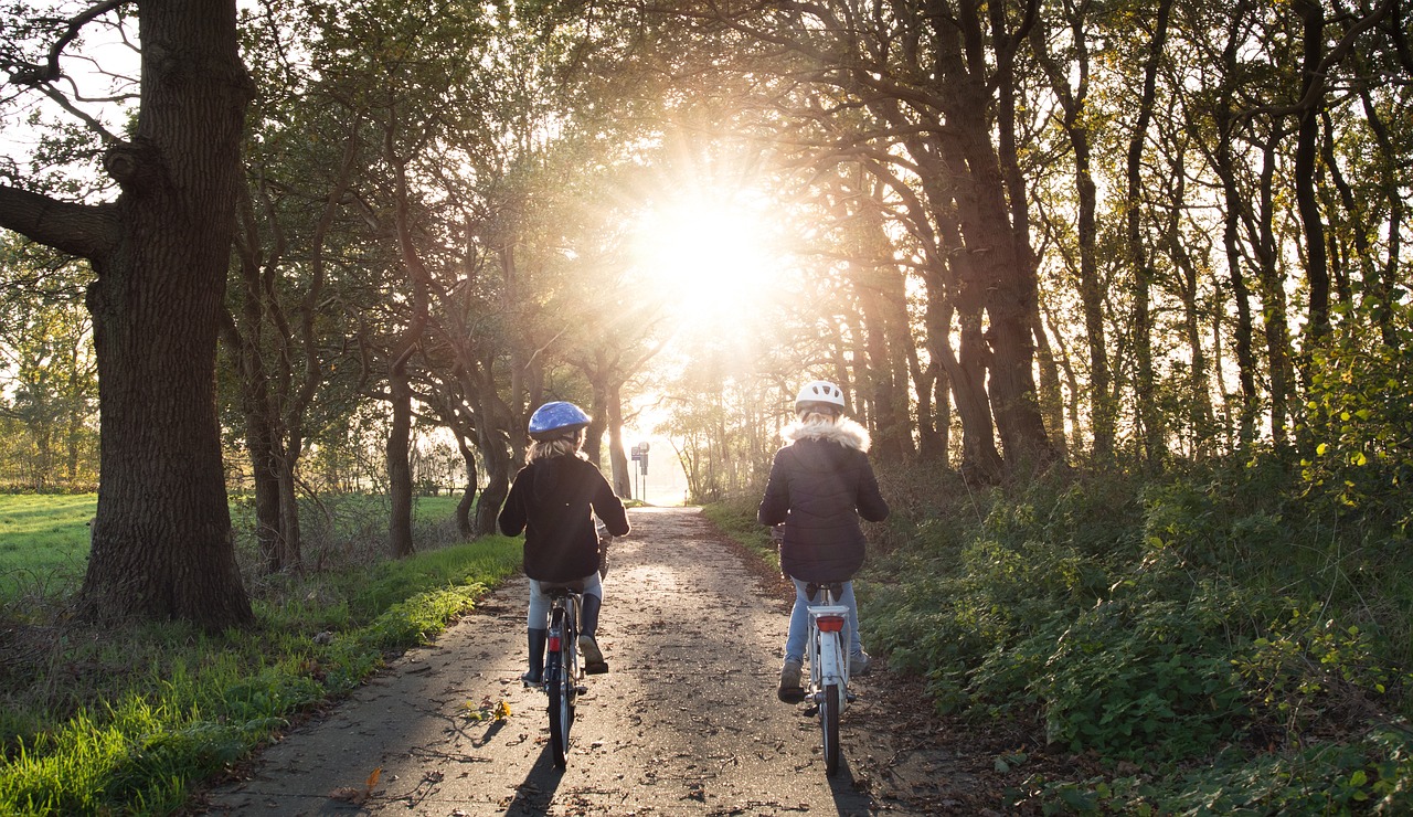 Adult and child riding bicycles in dirt country road