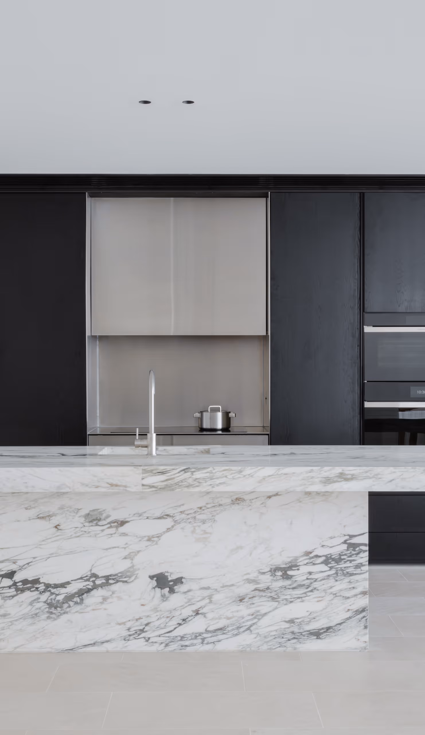 Kitchen island in Caprinia marble with black joinery, Muse Apartments