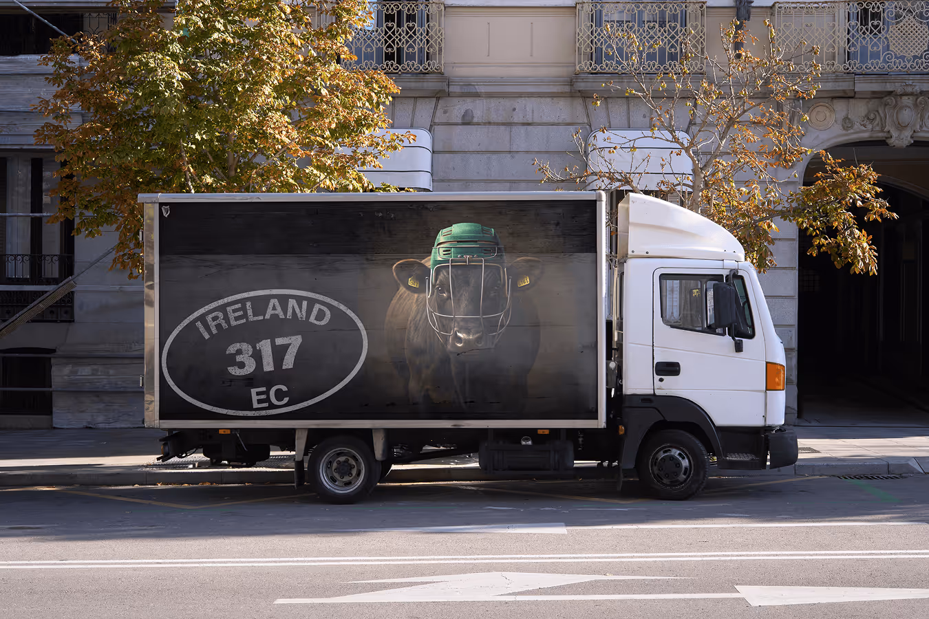 Poster of Cow wearing a hurling helmet with meat inspection stamp overlay, on side of a truck.
