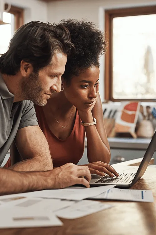 Image of a 2 individuals looking at a laptop 
