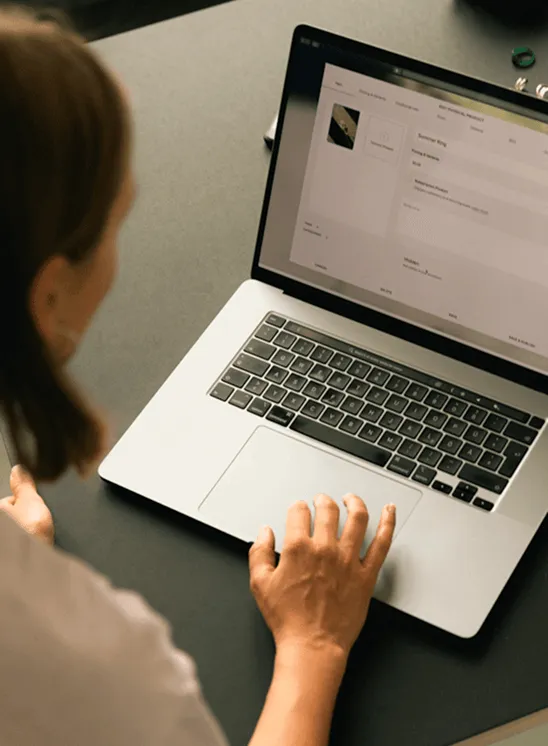 Person using laptop to manage business finances, illustrating working capital loan application process for Valiant Finance.