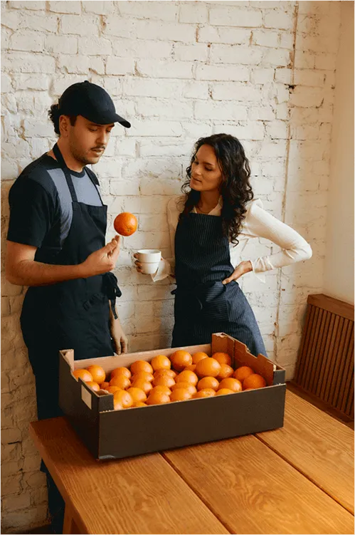 Image of a man and women holding a orange