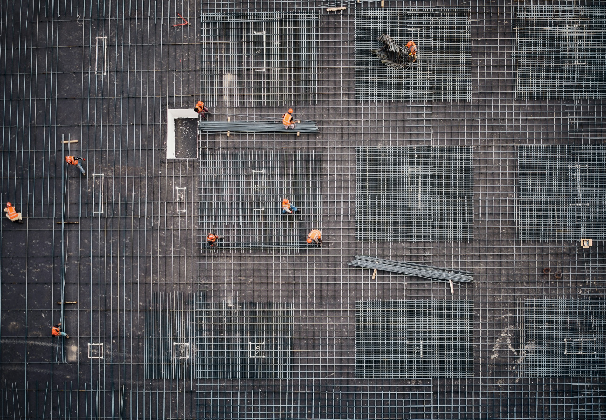 Aerial view of a construction site with workers on a reinforced slab