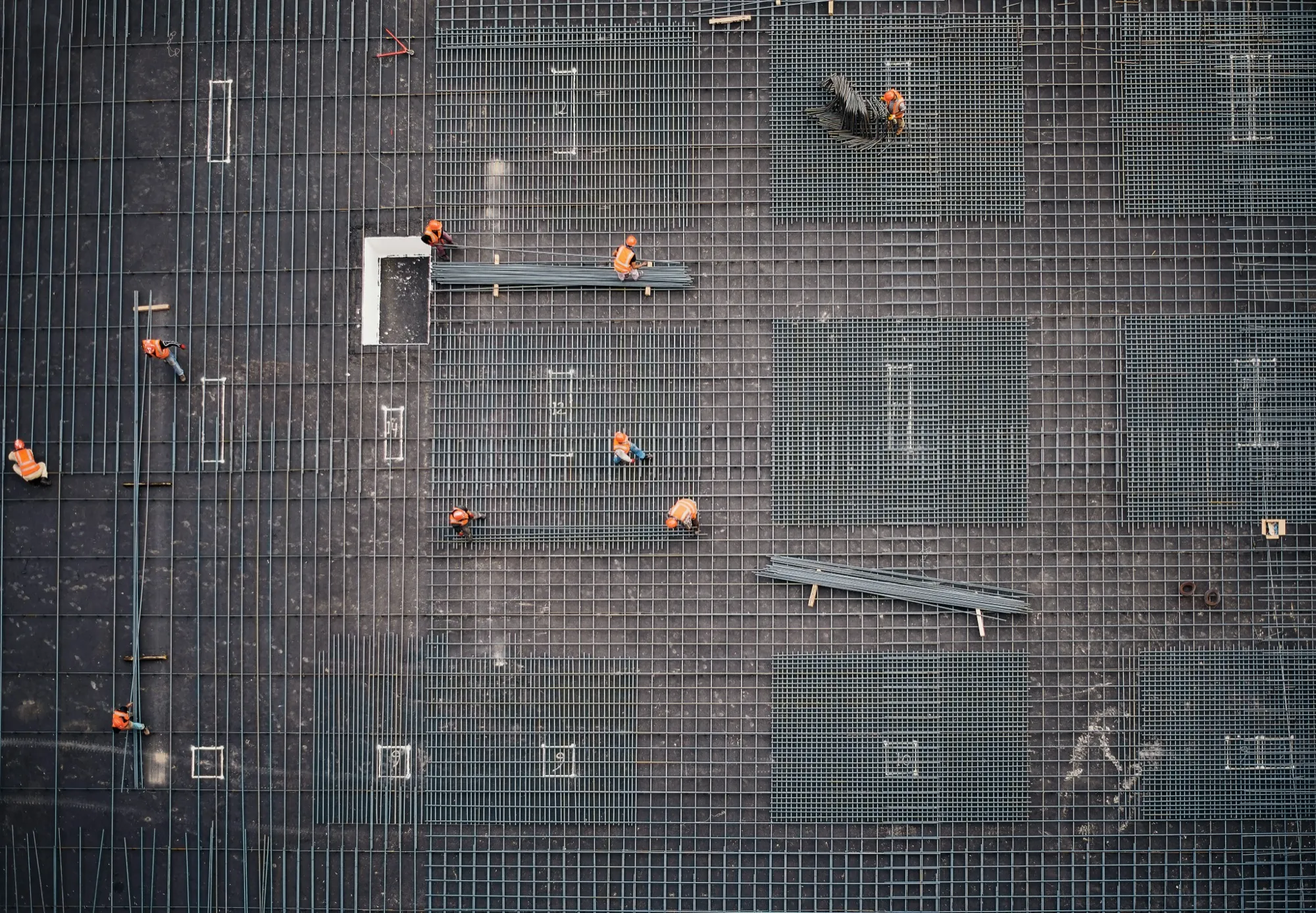 Aerial view of a construction site with workers on a reinforced slab
