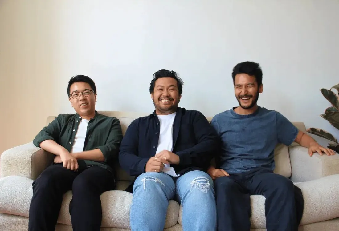 Three Valiant colleagues laughing together on a couch in the office