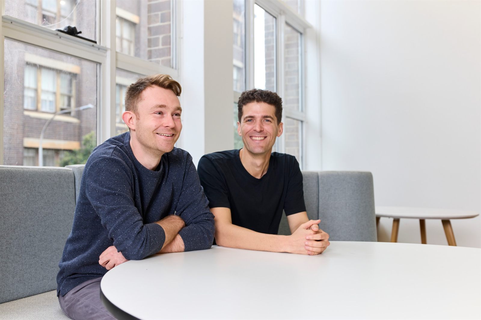 Valiant founders Alex Molloy and Ritchie Cotton at a table in the Sydney office