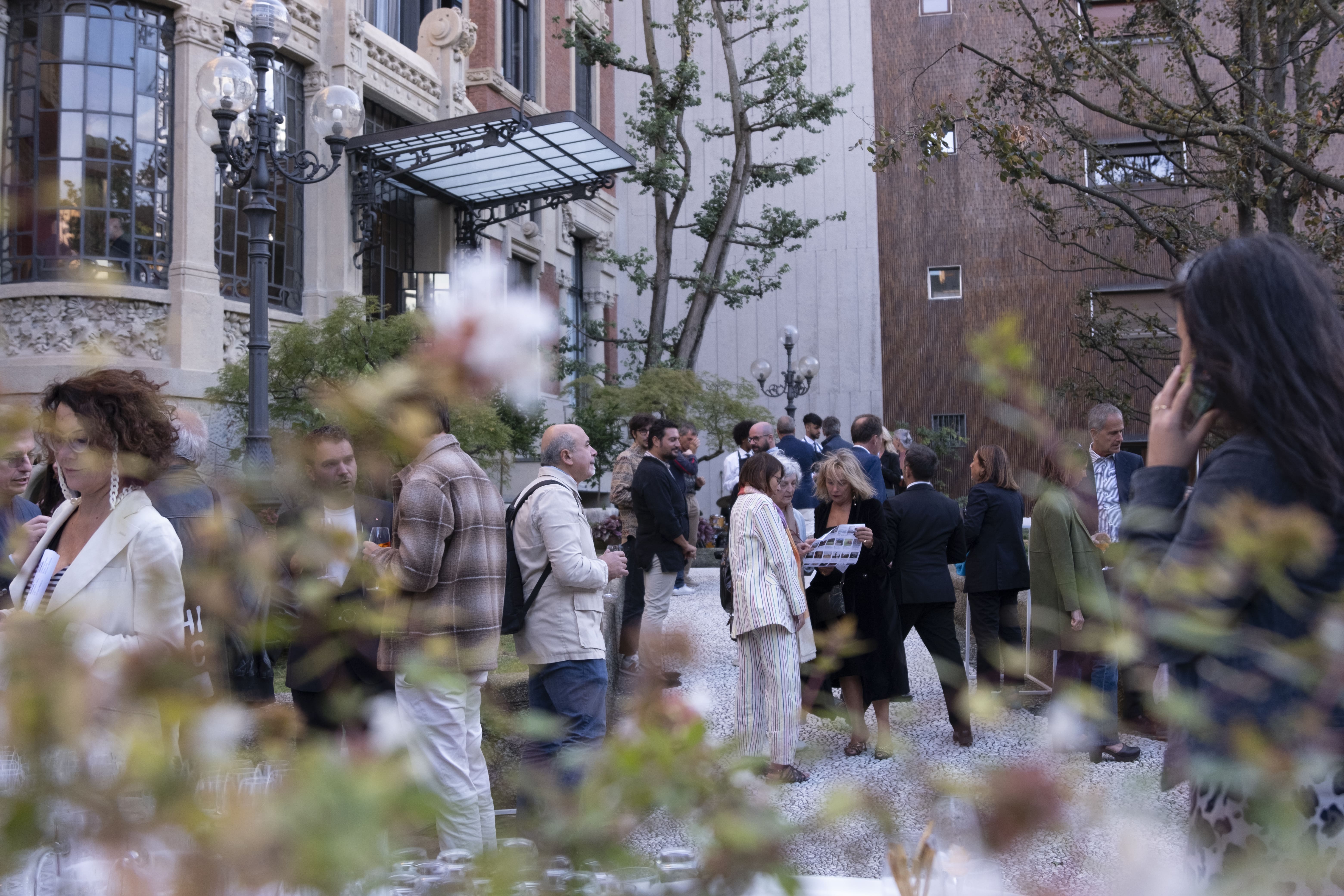 Due donne sorridenti con magliette arancioni etichettate 'You Sport' durante una maratona di staffetta, con volti truccati, circondate da altri corridori.