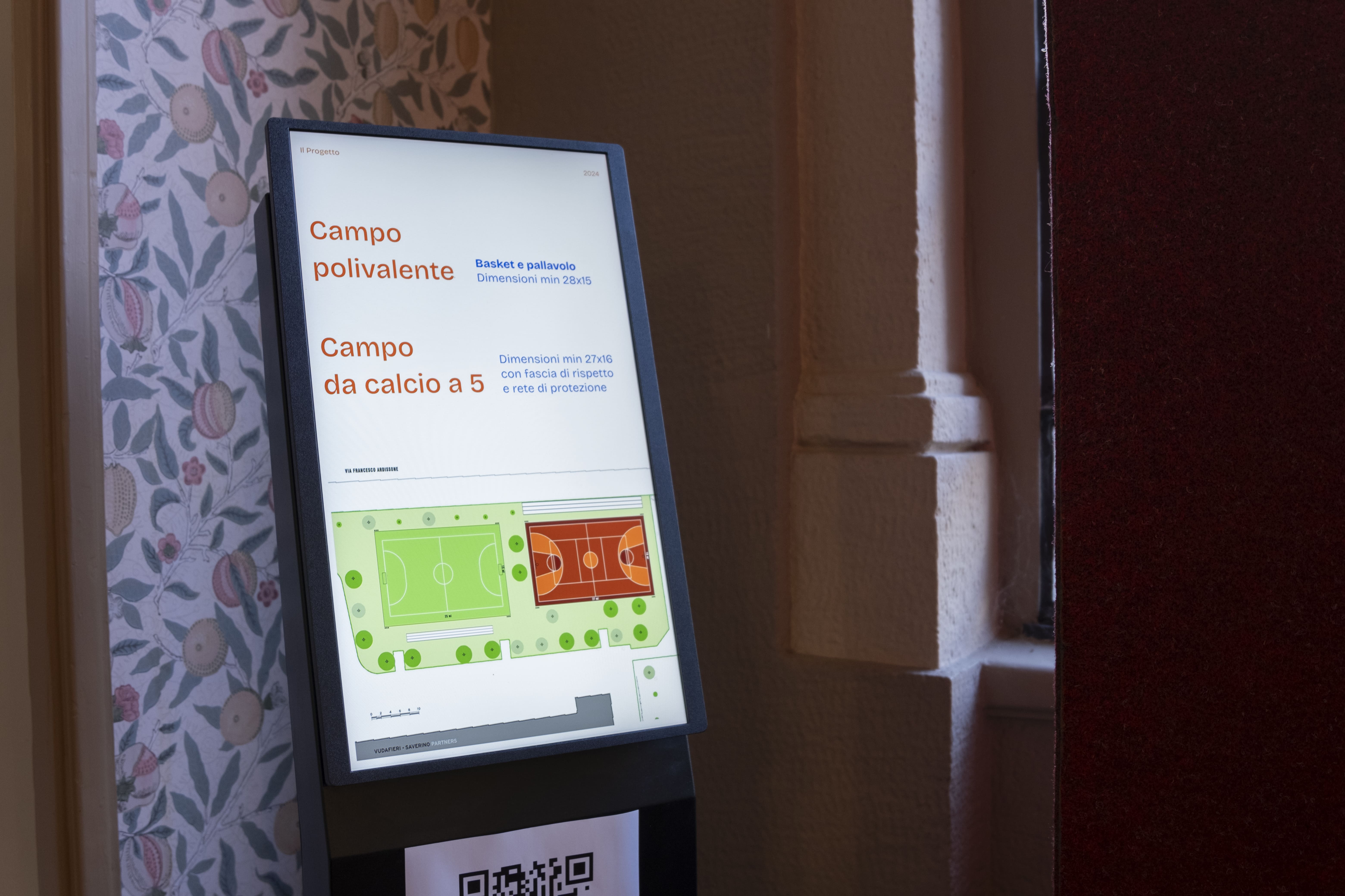 Gruppo di persone che partecipano a una corsa indossando magliette arancioni con scritte You Sport, alcune fanno il segno della vittoria e tengono uno striscione con la scritta 'Diversity is our normal'.