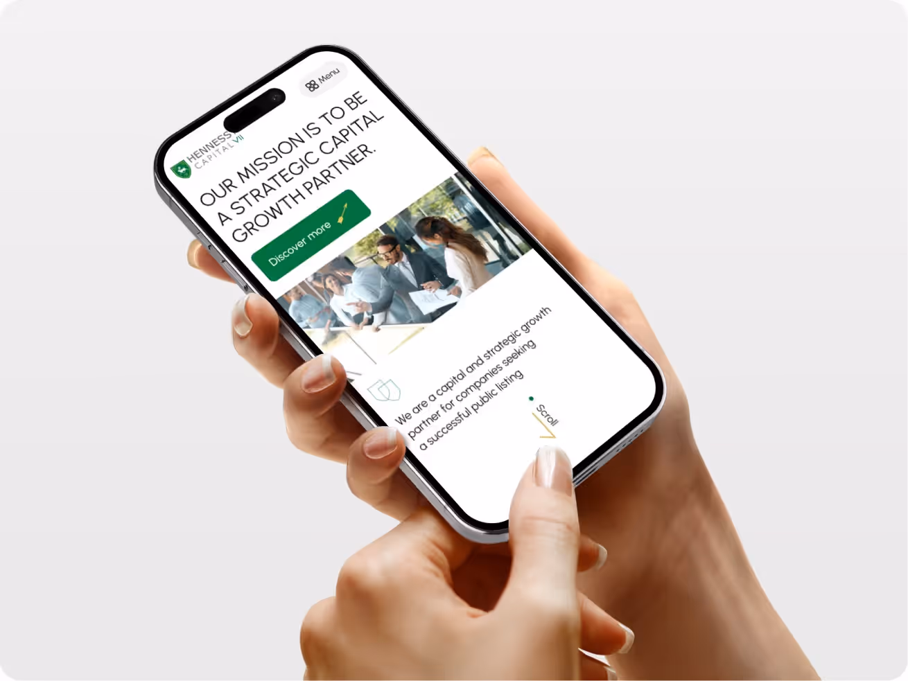 Hands holding a smartphone displaying a website with the text "Our mission is to be a strategic capital growth partner."