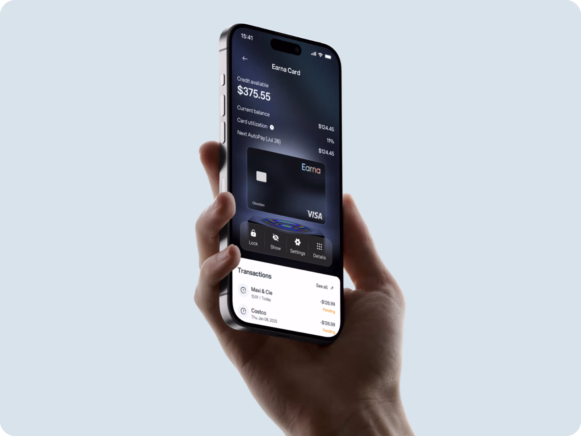A hand holds a smartphone displaying a banking app with a balance of $375.55. The interface shows recent transactions and card details.