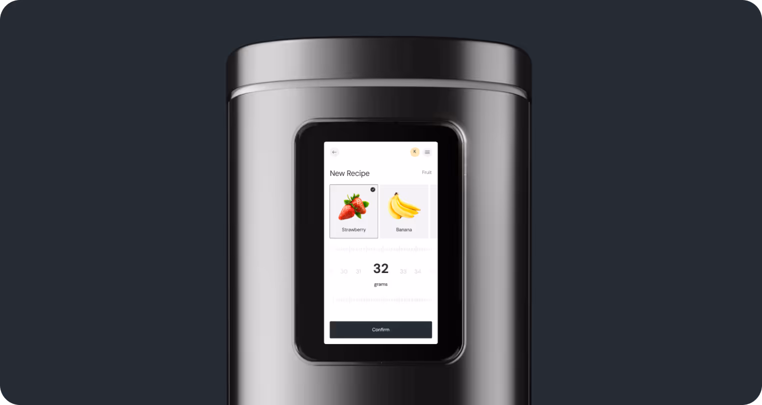A sleek, modern kitchen appliance with a digital screen showing a recipe for strawberries and bananas. The minimalist design conveys sophistication.