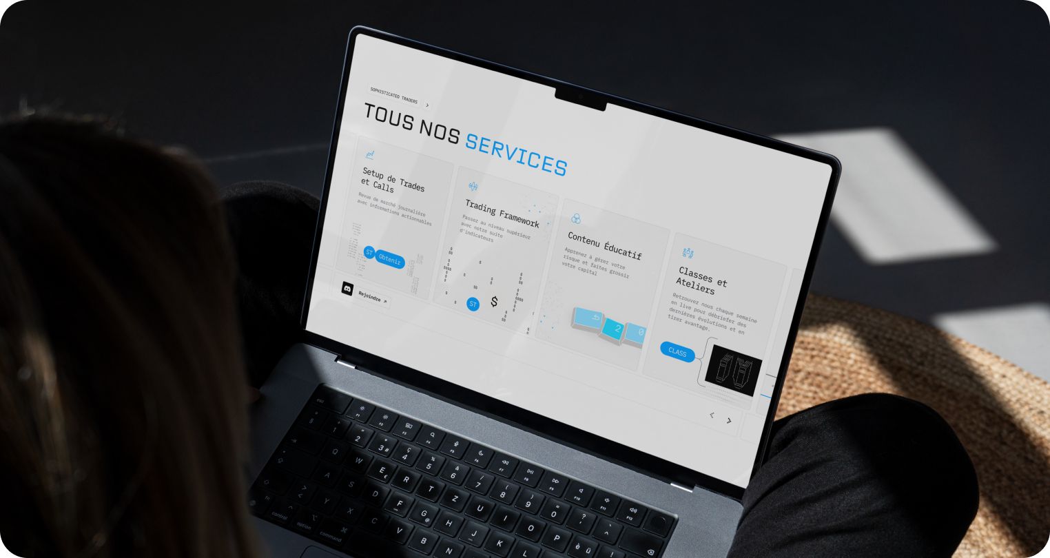 A person views a laptop displaying a website titled "Tous Nos Services" with service options. The setting is cozy with soft lighting, suggesting focus.