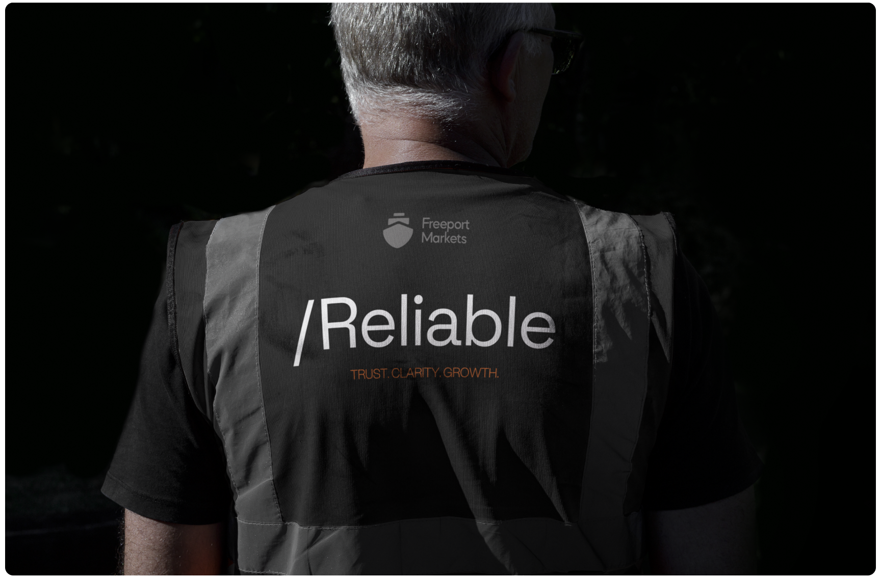 A man with gray hair, wearing a black vest. The back of the vest shows "Freeport Markets" with "Reliable" and "Trust, Clarity, Growth" in bold text.