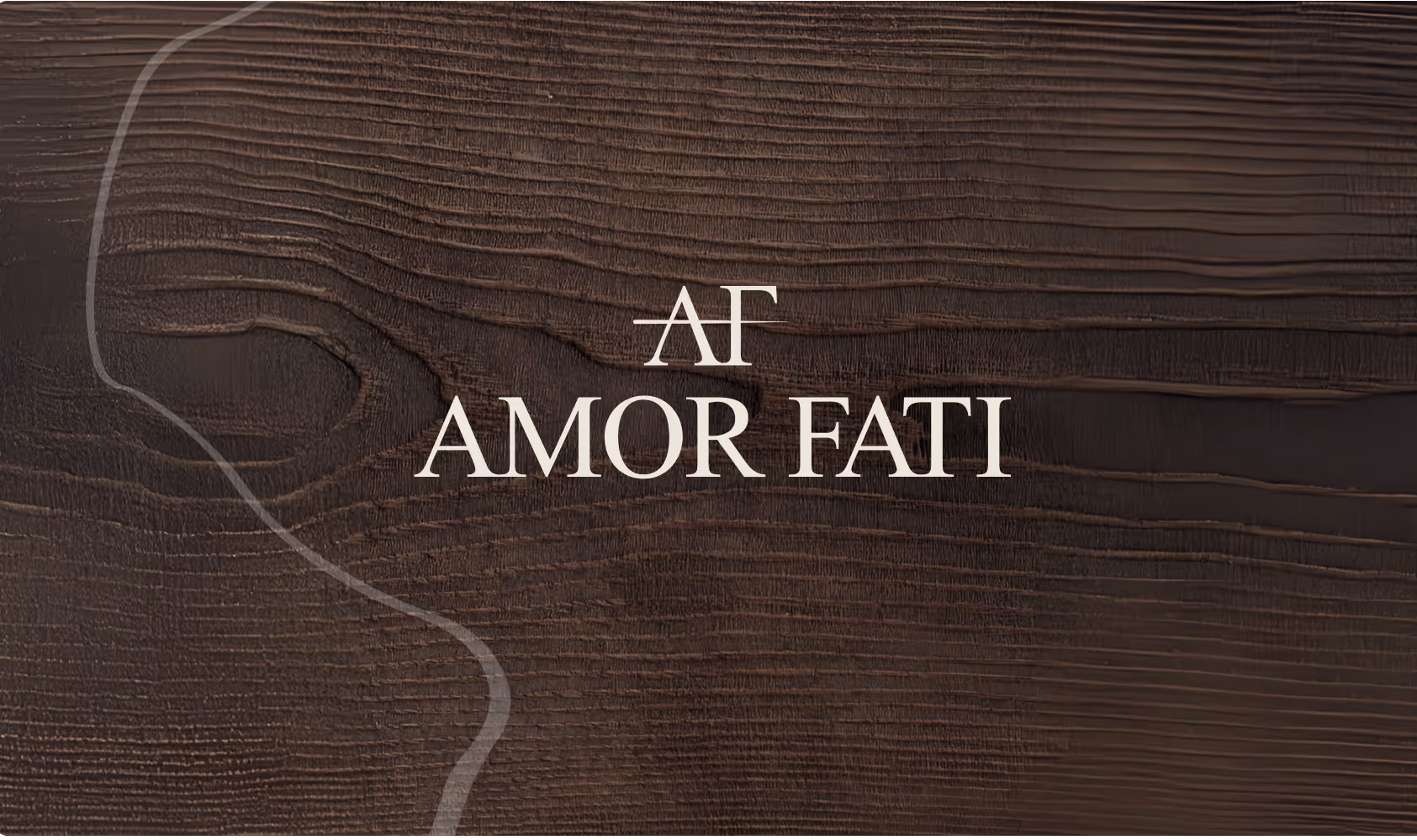 Text "AMOR FATI" is elegantly centered on a rich, dark wooden texture. The white lettering contrasts with the detailed wood grain.