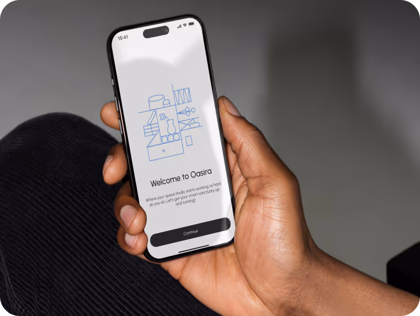A person holds a smartphone showing an app welcome screen with a minimalist blue line illustration. The text reads "Welcome to Oasira."