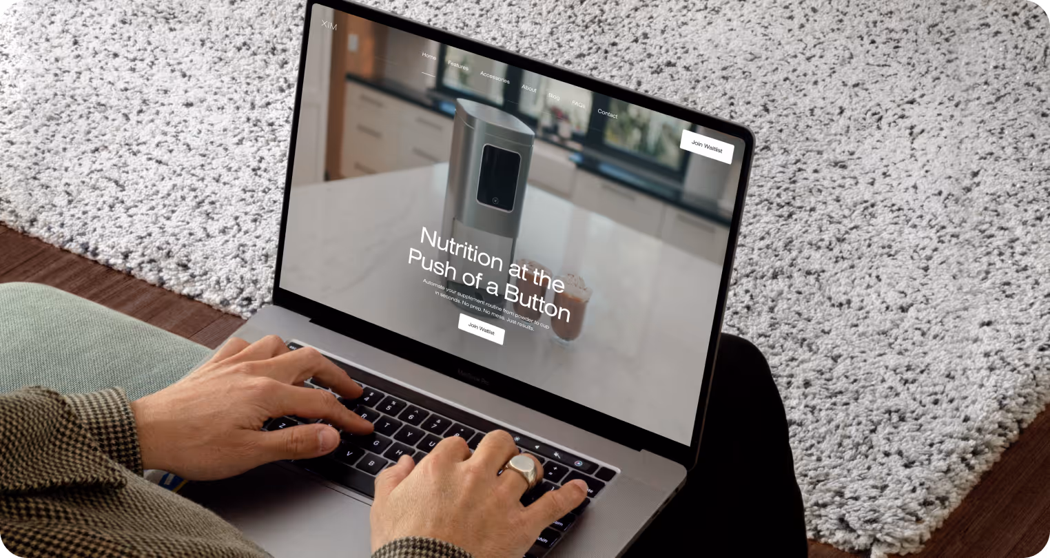 A person uses a laptop displaying a webpage with the text "Nutrition at the Push of a Button." The background shows a modern kitchen, conveying innovation.