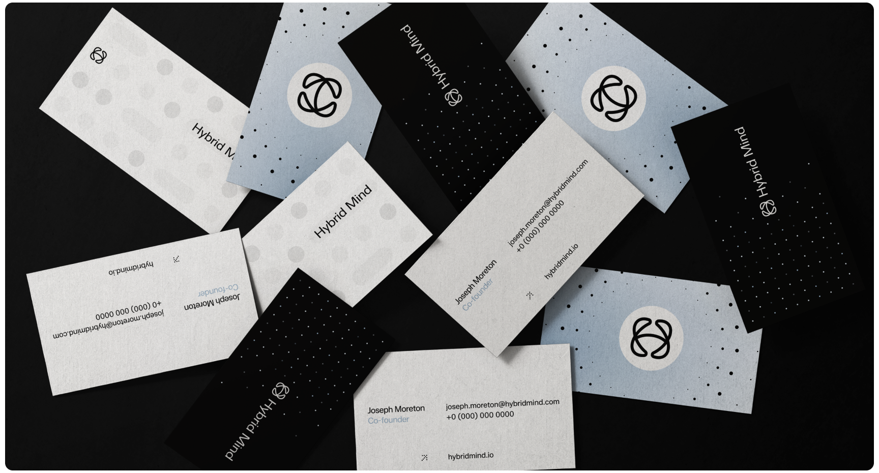A scattered arrangement of sleek business cards for "Hybrid Mind" against a dark background. Cards in black and white feature modern geometric patterns.