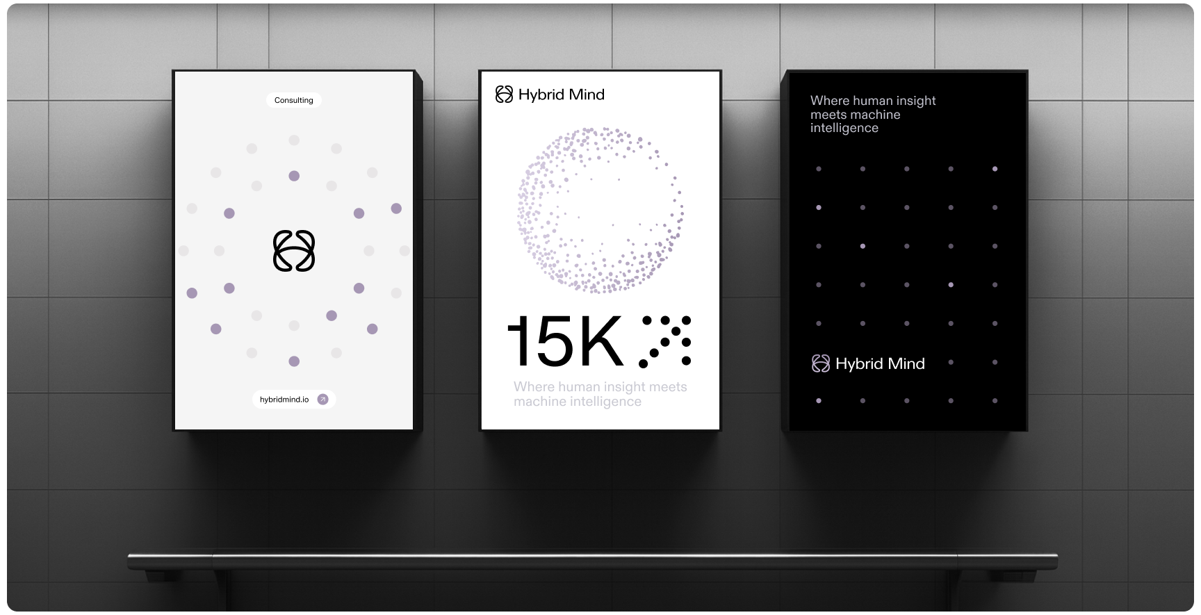 Three posters on a gray tiled wall. Left: White with abstract symbol, text "Connecting." Center: White with dotted sphere, text "Hybrid Mind 15K." Right: Black with dot grid, text "Where human insight meets machine intelligence."