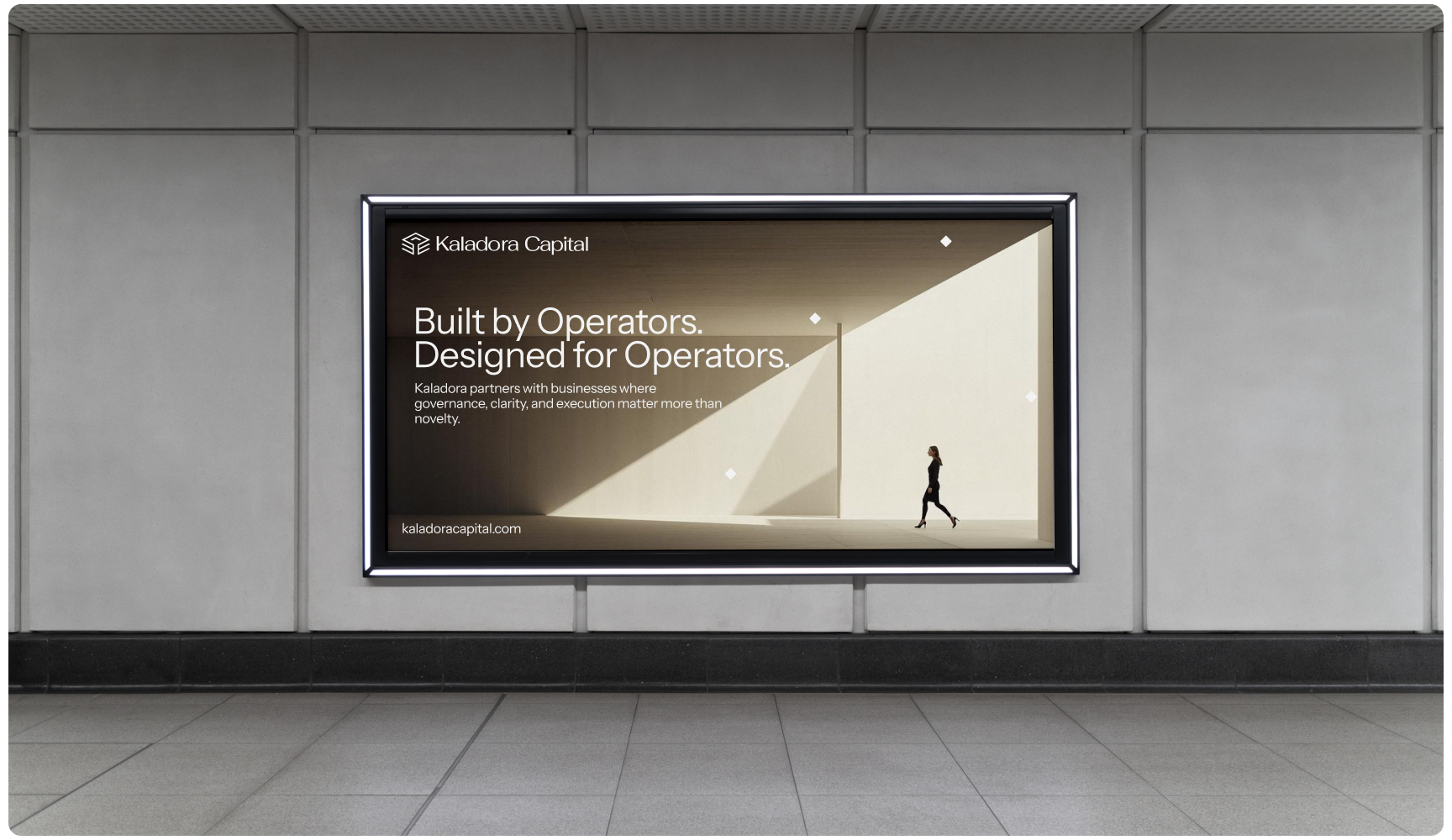 A backlit billboard in a subway station features "Built by Operators. Designed for Operators." A solitary figure walks beneath geometric shapes.