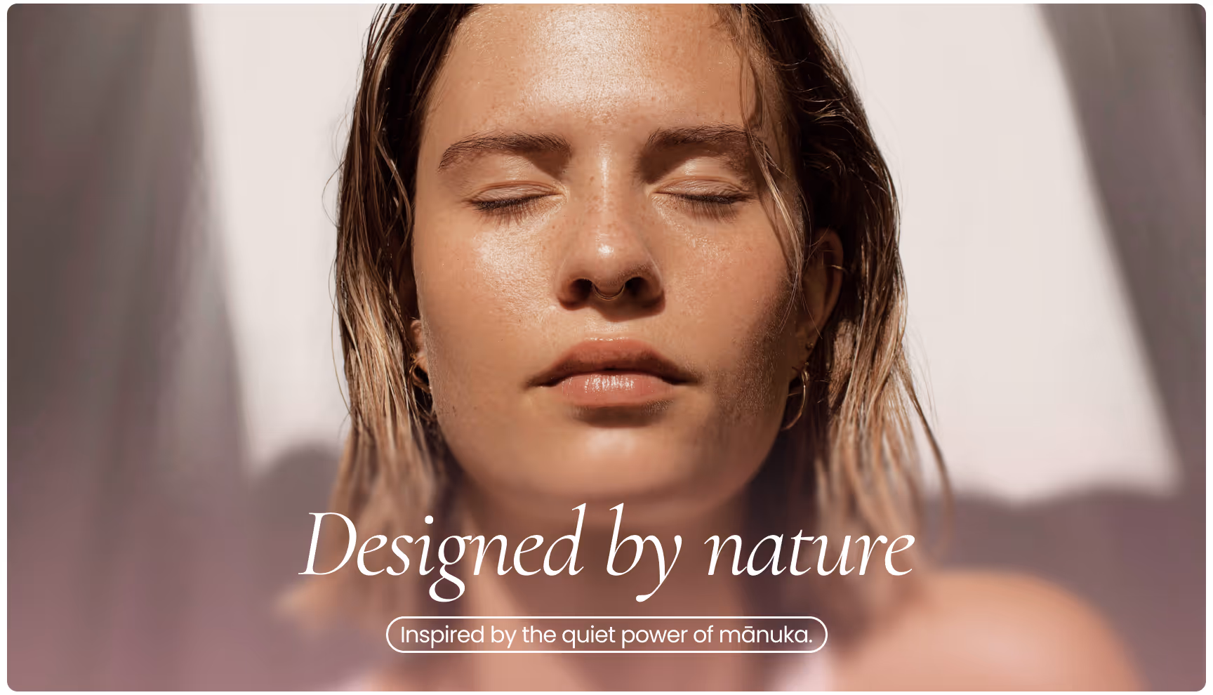 A person with closed eyes is basking in soft sunlight, conveying tranquility. The text reads, "Designed by nature," with, "Inspired by the quiet power of mānuka," below.