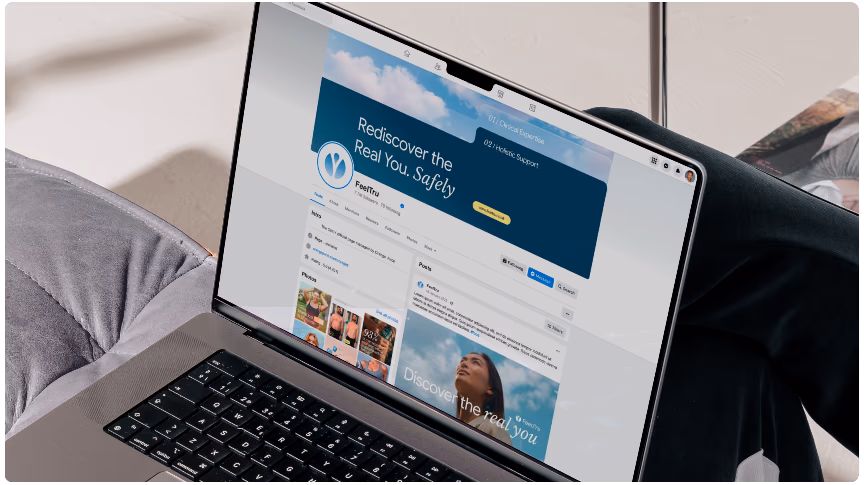 A person relaxes on a couch, using a laptop displaying a social media page. The screen shows vibrant images and the text "Rediscover the Real You, Safely."