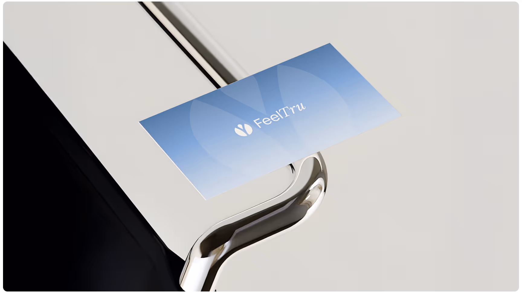 A sleek silver card holder displaying a blue business card with "FeelTru" in elegant white text. The modern and minimalist design suggests professionalism.