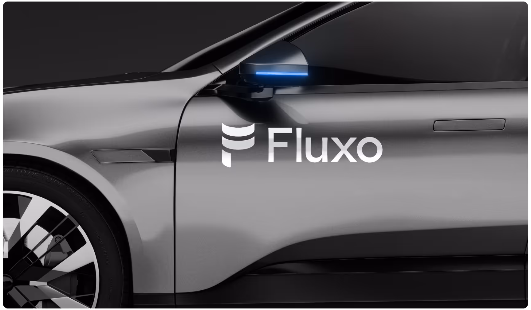 Silver futuristic car side view with white Fluxo logo branding on the door and a glowing blue side mirror accent.