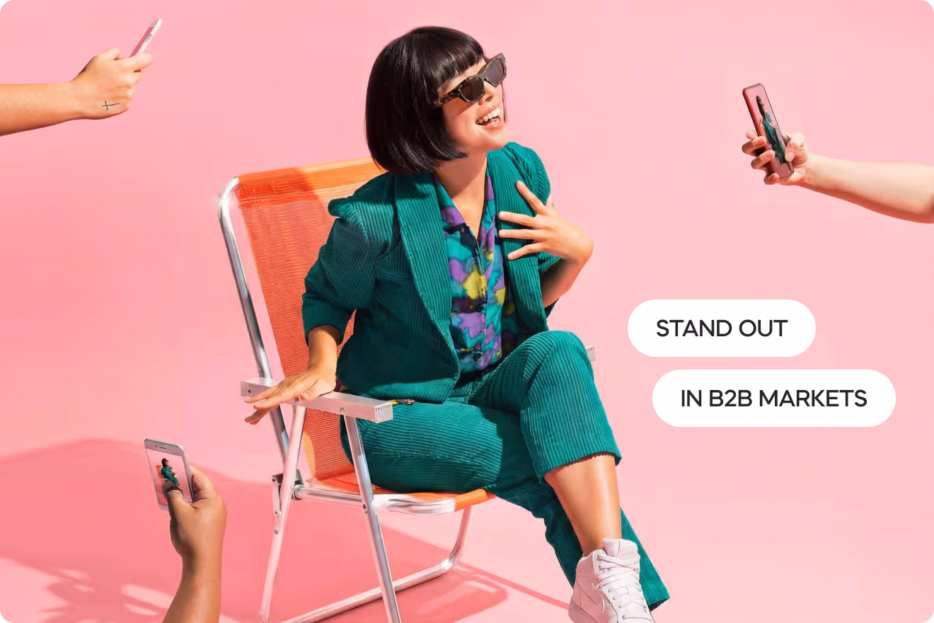 Person in a vibrant green suit posing for smartphone cameras against a pink backdrop, with text reading “Stand Out in B2B Markets,” symbolizing brand differentiation, visibility, and attention-grabbing marketing.