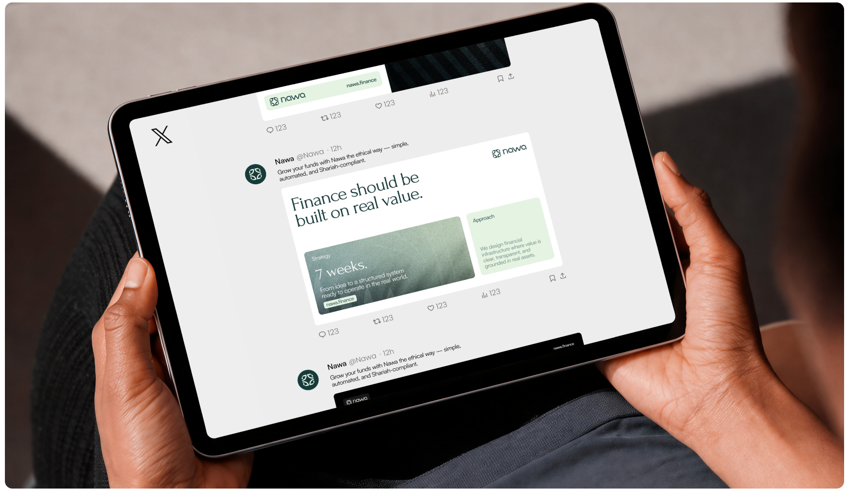 Hands hold a tablet displaying a social media post about finance and value, with muted green graphics and a clean, professional tone.