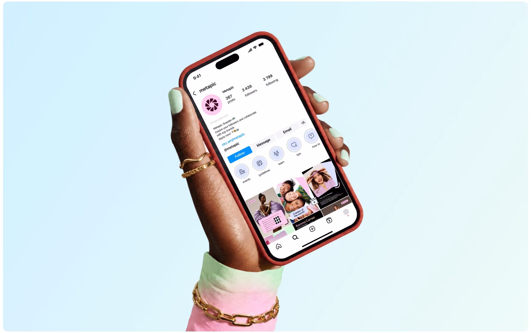 A hand holding a smartphone displaying the Metapic Instagram profile page against a soft pastel blue background.