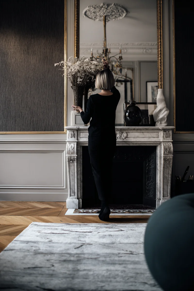 Décoratrice d'intérieur parisienne ajustant la décoration d'un salon