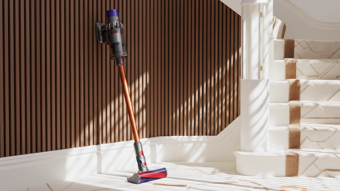 Aspirateur Dyson V10 en action sur un tapis clair, nettoyage et entretien des fibres à la maison.
