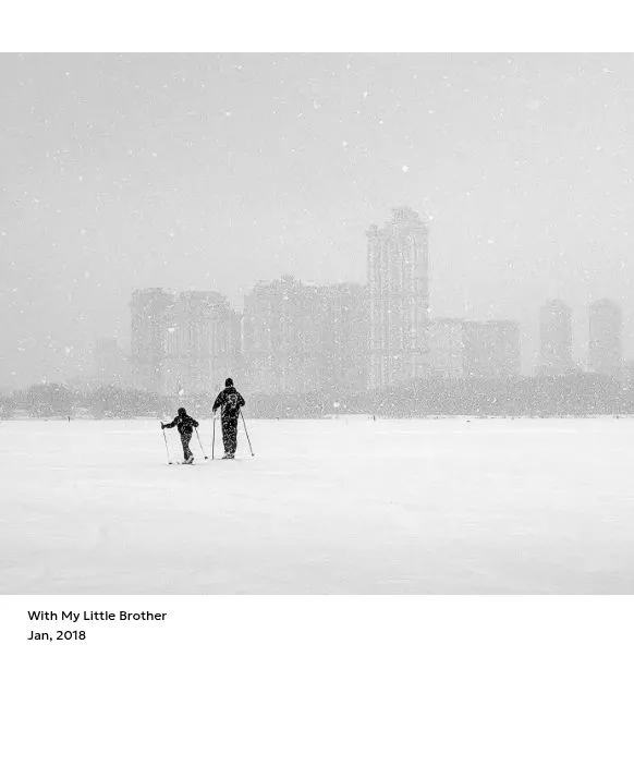 雪景色の中の二人を写したモノクロ写真と短い説明文を配置したフォトカレンダーのページ